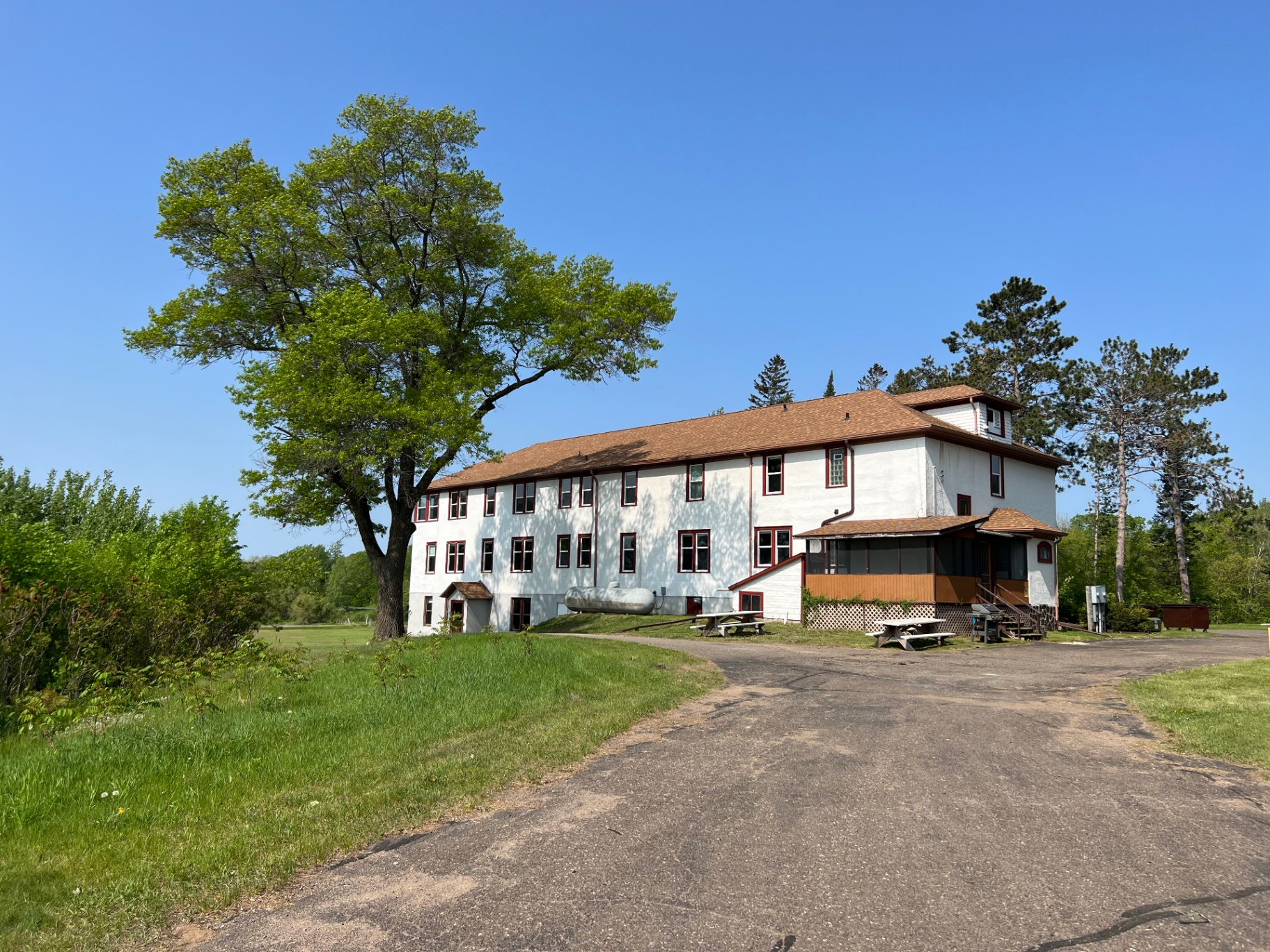 Sunny exterior view with large tree